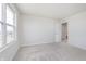 Bright bedroom with neutral carpet, white walls and trim, and a window showcasing the outside neighborhood at 7164 Firestone Rd, Whitestown, IN 46052