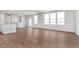 Spacious living area showcasing wood floors and a connection to a kitchen with modern finishes and design at 7164 Firestone Rd, Whitestown, IN 46052