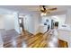 Open living area with hardwood floors, ceiling fan, and an adjacent modern kitchen at 7468 Prairie Lake Dr, Indianapolis, IN 46256