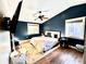 Spacious main bedroom with dark blue walls, hardwood floors, and a king-size bed at 8104 Glenwillow Ln # 208, Indianapolis, IN 46278