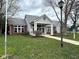 Clubhouse exterior with brick and light gray siding, covered entrance, and manicured lawn at 8104 Glenwillow Ln # 208, Indianapolis, IN 46278