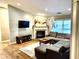Spacious living room featuring hardwood floors, a cozy fireplace, and an L-shaped sectional sofa at 8104 Glenwillow Ln # 208, Indianapolis, IN 46278
