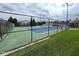 Fenced tennis court featuring blue and green surface with lighting at 8104 Glenwillow Ln # 208, Indianapolis, IN 46278