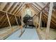 Unfinished attic space with wooden beams and shelving at 10295 Summerlin Way, Fishers, IN 46037