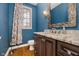 Elegant powder room with dark wood vanity, granite countertop, and blue walls at 10295 Summerlin Way, Fishers, IN 46037