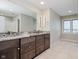 Double vanity bathroom with granite countertop and large mirror at 10295 Summerlin Way, Fishers, IN 46037