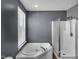 Bathroom featuring a white bathtub, glass shower, and large window with natural light at 11054 Dura Dr, Indianapolis, IN 46229