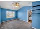 Bright bedroom featuring a ceiling fan, window and shelves, and an entry into a bathroom at 11054 Dura Dr, Indianapolis, IN 46229