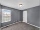 Bedroom with gray walls, neutral carpet, window with blinds, ceiling light, and white door at 11054 Dura Dr, Indianapolis, IN 46229
