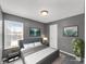 Staged bedroom with gray walls, neutral carpet, window with blinds, ceiling light, and modern décor at 11054 Dura Dr, Indianapolis, IN 46229