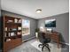 Office space featuring a wooden desk, comfy chair, storage shelf and a bright window for ample natural light at 11054 Dura Dr, Indianapolis, IN 46229