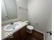 Clean bathroom with a single sink vanity, toilet and wood-look flooring at 11663 Congressional Ln, Indianapolis, IN 46235