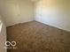 Bedroom featuring neutral carpet and white walls with a closet and a door at 11663 Congressional Ln, Indianapolis, IN 46235