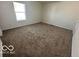Spacious bedroom with neutral carpet and window at 11663 Congressional Ln, Indianapolis, IN 46235