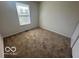 Bright bedroom featuring neutral carpet, white walls and a window bringing in natural light at 11663 Congressional Ln, Indianapolis, IN 46235