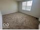 Bedroom with neutral carpeting and a large window at 11663 Congressional Ln, Indianapolis, IN 46235