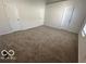 Large bedroom with carpet and multiple doors at 11663 Congressional Ln, Indianapolis, IN 46235