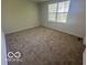 Bedroom featuring neutral carpet, white walls, and a large window bringing in natural light at 11663 Congressional Ln, Indianapolis, IN 46235