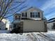 Two-story house with beige siding, brown shutters, and a two-car garage at 11663 Congressional Ln, Indianapolis, IN 46235