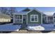 Charming green house with a white porch and snowy front yard at 1407 N Pershing Ave, Indianapolis, IN 46222