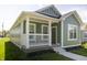 Inviting green home featuring a cozy front porch and manicured garden, ideal for relaxation at 1407 N Pershing Ave, Indianapolis, IN 46222