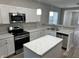 Modern kitchen with white cabinets, island, and stainless steel appliances at 1407 N Pershing Ave, Indianapolis, IN 46222