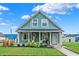 Charming teal house with a covered porch and well-manicured lawn at 2015 Columbia Ave, Indianapolis, IN 46202