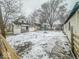 Fenced backyard with basketball hoop and snowy ground at 216 W 27Th St, Anderson, IN 46016