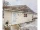 Modest home featuring vinyl siding, a white door, and a small window, presenting an opportunity for renovation at 216 W 27Th St, Anderson, IN 46016