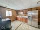 Kitchen with wood cabinets and stainless steel fridge at 216 W 27Th St, Anderson, IN 46016
