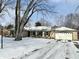 Ranch style home with stone exterior, snow covered lawn and driveway at 2526 Pleasant W Way, Carmel, IN 46280