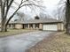 Ranch home with stone exterior, attached garage, and mature trees at 2526 Pleasant W Way, Carmel, IN 46280