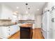 Modern kitchen featuring white cabinetry, a wooden center island and stainless-steel appliances at 40 Wildwood Dr, Carmel, IN 46032