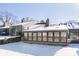 Rear view of home showing a sunroom and snowy yard at 5060 Hawthorne Way # 11, Avon, IN 46123