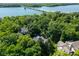 An aerial view of a luxury home surrounded by lush greenery, near a scenic lake with a bridge at 5508 Bay Landing Cir, Indianapolis, IN 46254