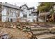 Exterior shot of the back of the home showcases a sloping yard with rock stairs, gravel, and mature landscaping at 5508 Bay Landing Cir, Indianapolis, IN 46254