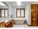 Bright bathroom featuring a soaking tub, and a vanity with marble countertops and natural light at 5508 Bay Landing Cir, Indianapolis, IN 46254