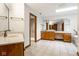 Bright bathroom featuring double sink vanity, tiled floors, large mirrors and natural light at 5508 Bay Landing Cir, Indianapolis, IN 46254