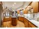 Spacious kitchen featuring warm wood cabinets, center island, tile backsplash, and modern appliances at 5508 Bay Landing Cir, Indianapolis, IN 46254