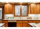Kitchen showcases wood cabinets, window over sink, and dark countertops with decorative tile backsplash at 5508 Bay Landing Cir, Indianapolis, IN 46254