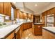 Bright and spacious kitchen features warm wood cabinets, island, and modern appliances with hardwood floors at 5508 Bay Landing Cir, Indianapolis, IN 46254