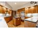 Well-lit kitchen with warm wood cabinets, a kitchen island, modern appliances and hard wood floors at 5508 Bay Landing Cir, Indianapolis, IN 46254