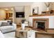Bright living room features a tiled fireplace, hardwood floors, a large TV, and comfortable seating at 5508 Bay Landing Cir, Indianapolis, IN 46254
