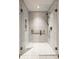 Modern glass walk-in shower with white tile, a rainfall shower head and sleek bronze fixtures at 5508 Bay Landing Cir, Indianapolis, IN 46254