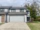 Two-story home featuring a large garage, well-maintained lawn, and welcoming entrance, showcasing curb appeal at 8207 Shorewalk Dr, Indianapolis, IN 46236