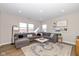 L-shaped living room with a gray sectional sofa and large windows at 8576 Jeff Cir, Brownsburg, IN 46112