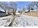 Wide shot of a snowy backyard and a detached one car garage with a driveway and a walkway at 3614 E New York St, Indianapolis, IN 46201