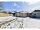Snowy backyard with view of house exteriors and a new wooden fence at 3614 E New York St, Indianapolis, IN 46201