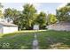 Large backyard with three storage buildings with mature trees and well kept lawn at 3614 E New York St, Indianapolis, IN 46201