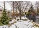 Snowy backyard with a wood fence, evergreen trees, and a metal gate at 4561 Summersong Rd, Zionsville, IN 46077